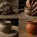 Hand shaping pottery clay on a wheel, illustrating the pottery-making process from start to finish